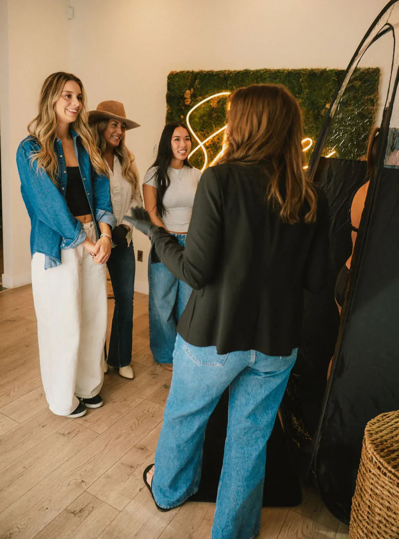 A Sjolie educator coaching students beside a spray tan tent.