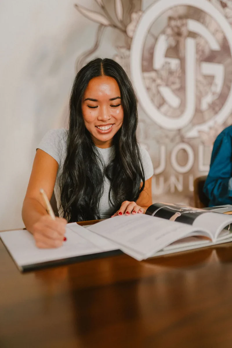 A student taking notes during a Sjolie spray tan training class.